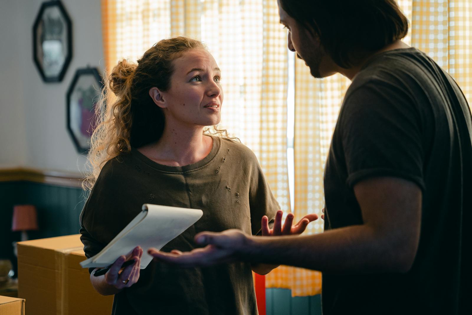 Worried couple with notebook looking at each other, renters